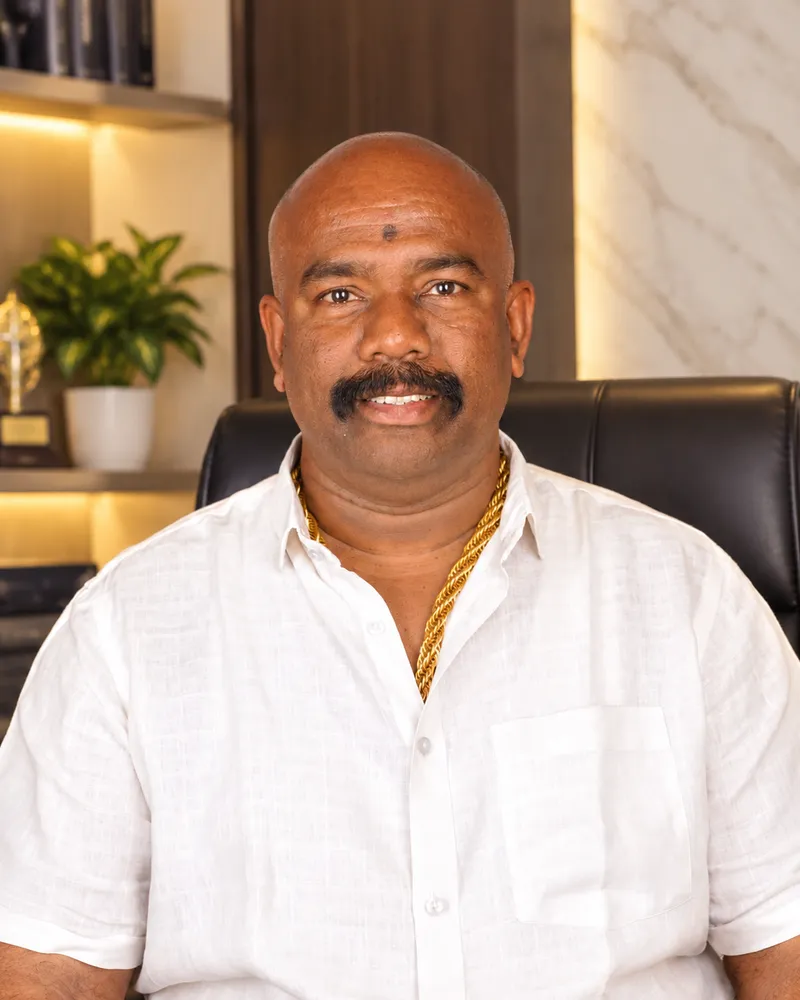 Portrait of Mr. Yesu Krishna, Founder and Owner of JY Developers, seated in his office
